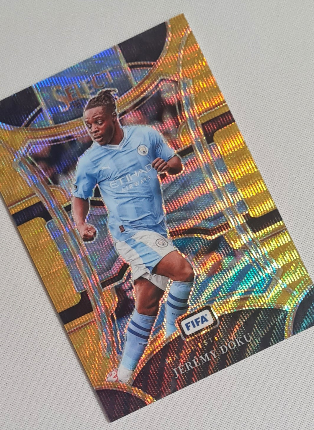 Jeremy Doku - 2023/24 Panini Select FIFA Soccer Prizm Man City #114 Mezzanine Gold Wave/10